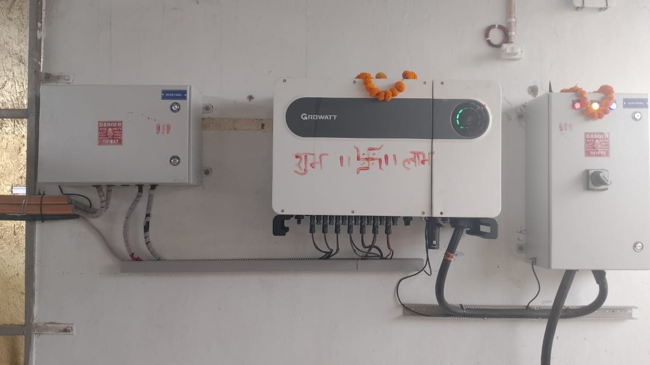 Growatt 75 kW grid tie inverter between its DC and AC distribution panels at Arihant Cold Storage, Okhla, garlanded on commissioning day