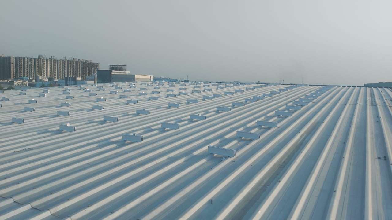 Mounting rails screwed across the ribs of the metal sheet roof before the modules were fitted at Prabhat Namkeen, Surajpur, Greater Noida