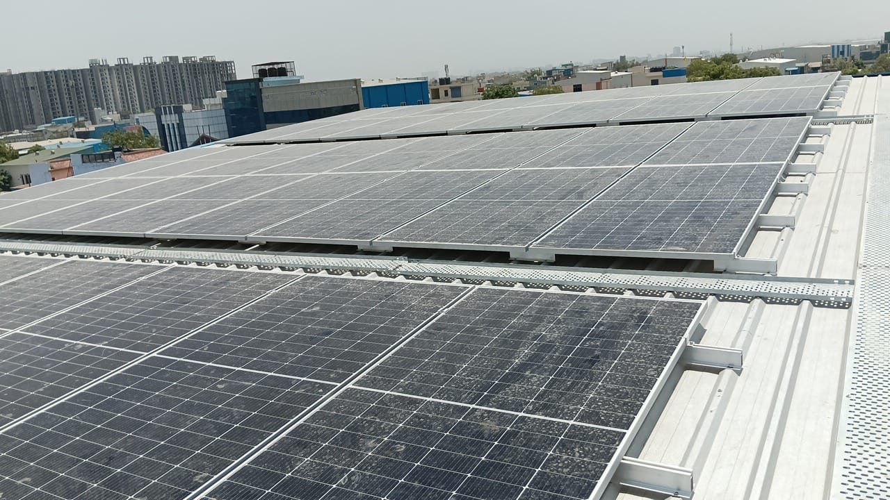 40 kW rooftop solar array on the tin shed roof of the Prabhat Namkeen production unit in Surajpur, Greater Noida, with a cable tray between the rows